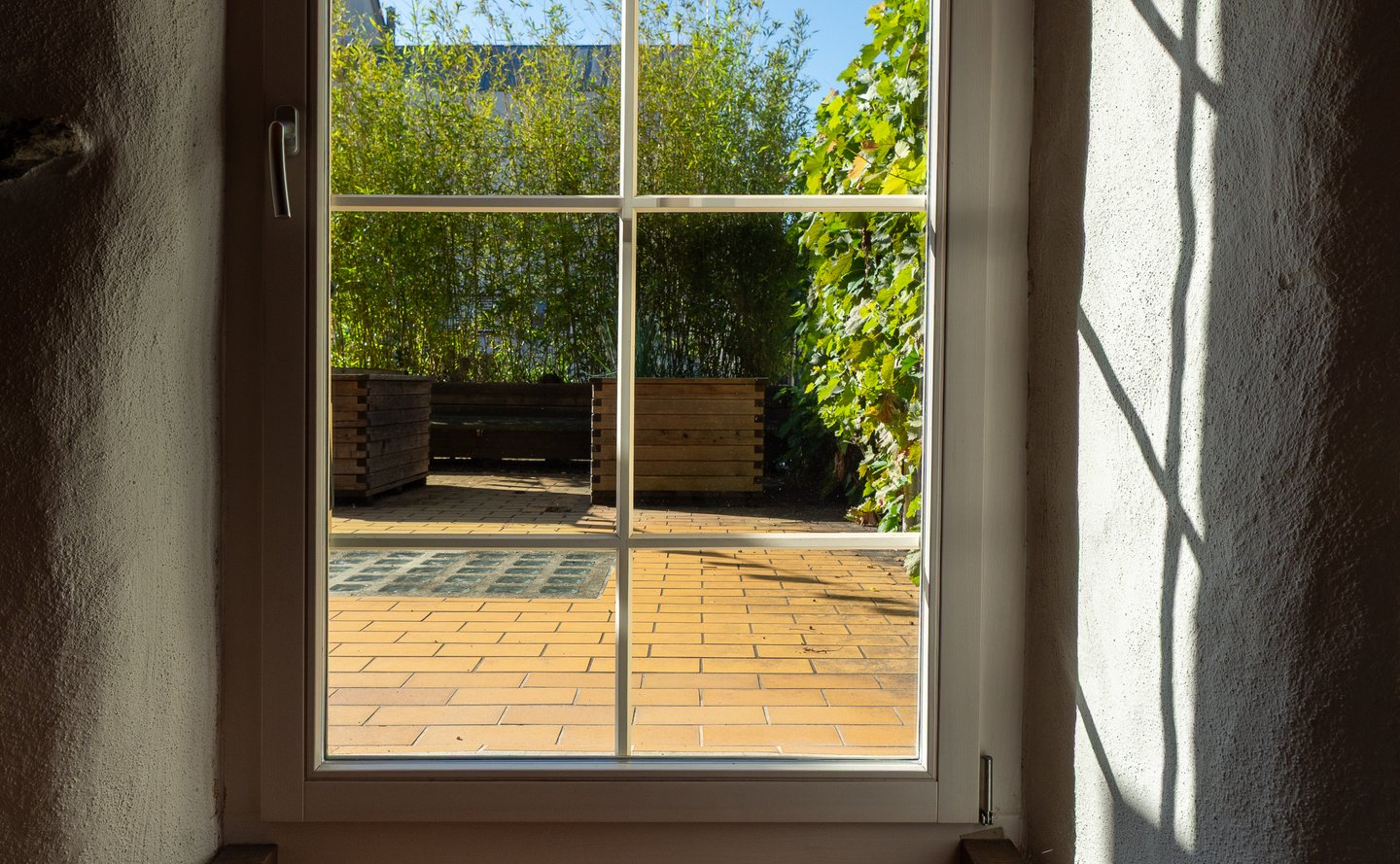 Terrasse mit gelben Boden und grüner Bepflanzung